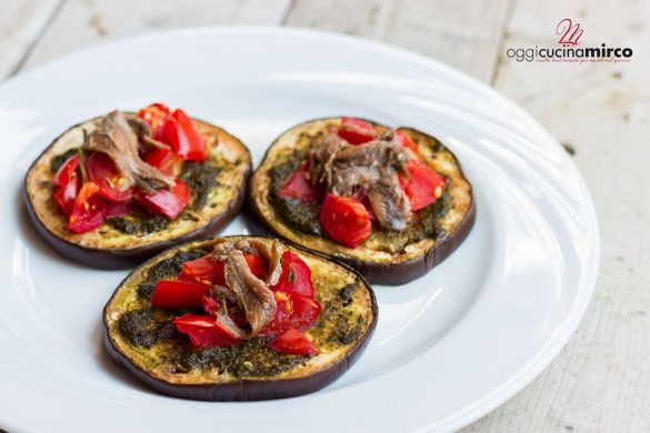 Melanzane al forno con pesto, pomodorini e acciughe