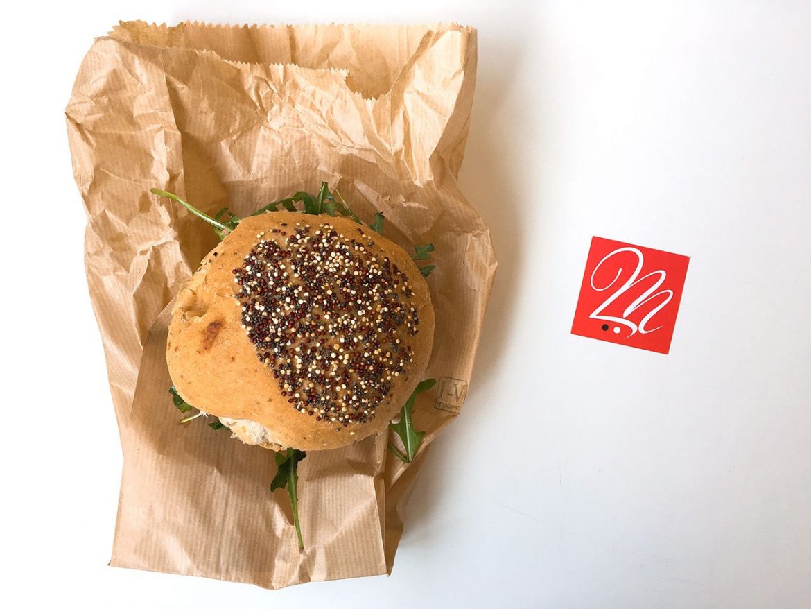 Panino con hamburger, pomodori secchi, rucola e mandorle