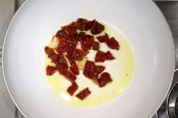 preparazione del sugo di pomodori secchi, tonno e olive nere