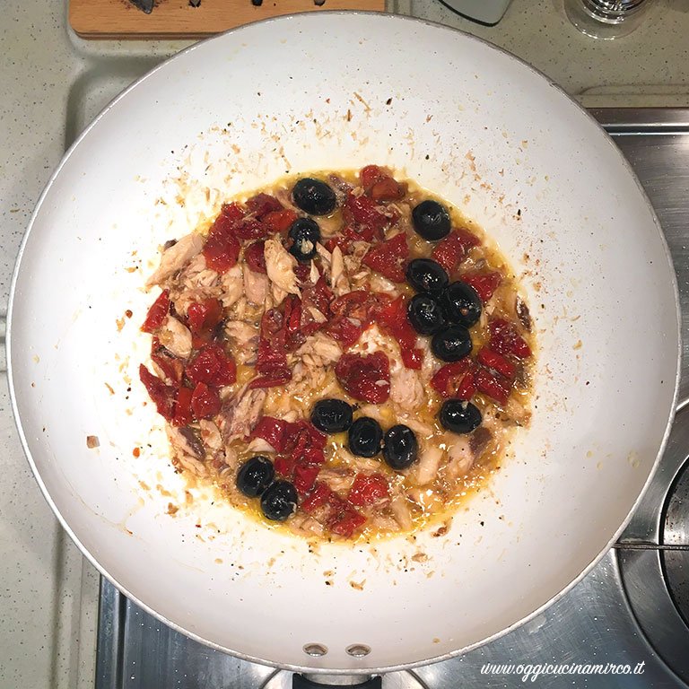 Preparazione della pasta con sugo di pomodori secchi, tonno e olive nere