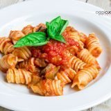 sugo di melanzane con pasta su piatto bianco